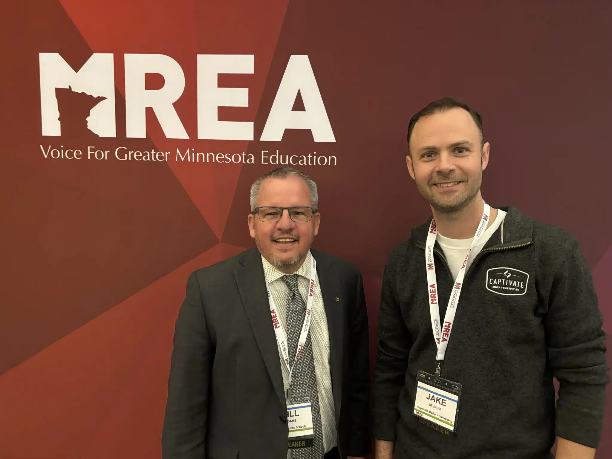 Dr. Bill Adams (Left) and Jake Sturgis (right) in front of an MREA banner