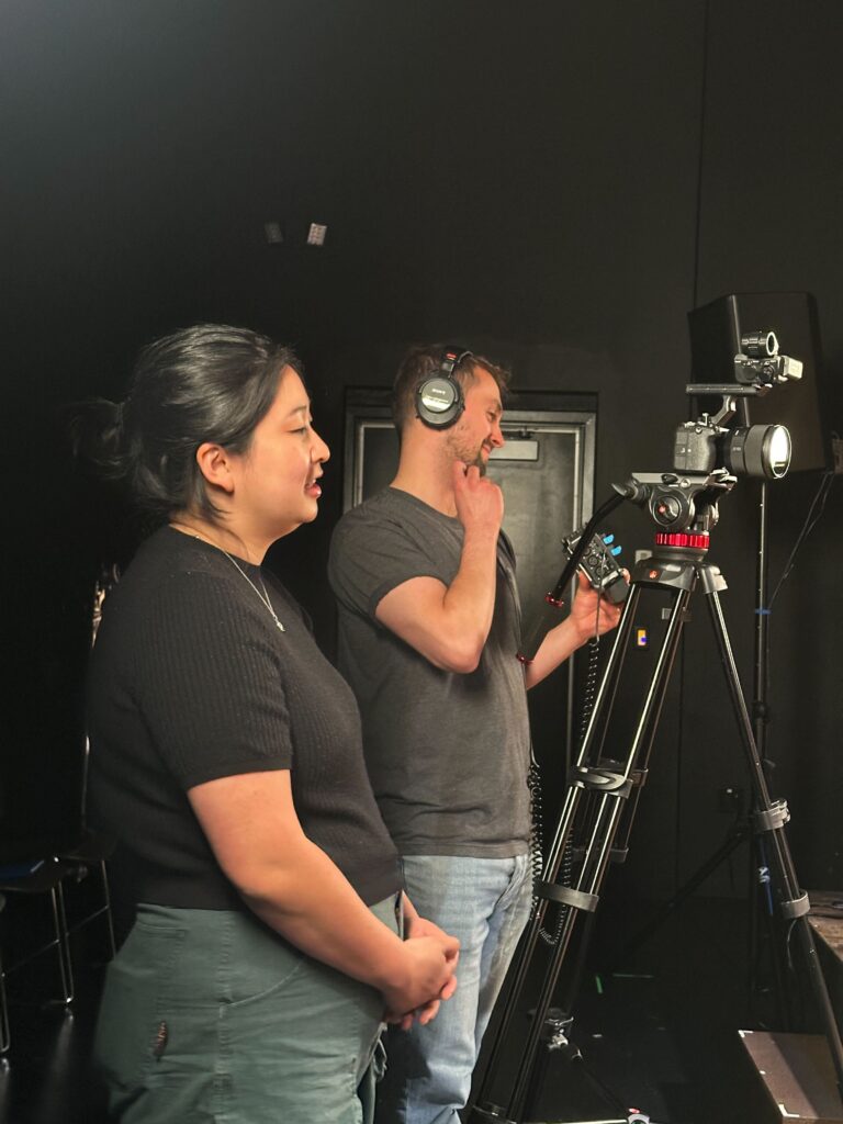 two producers filming with a camera