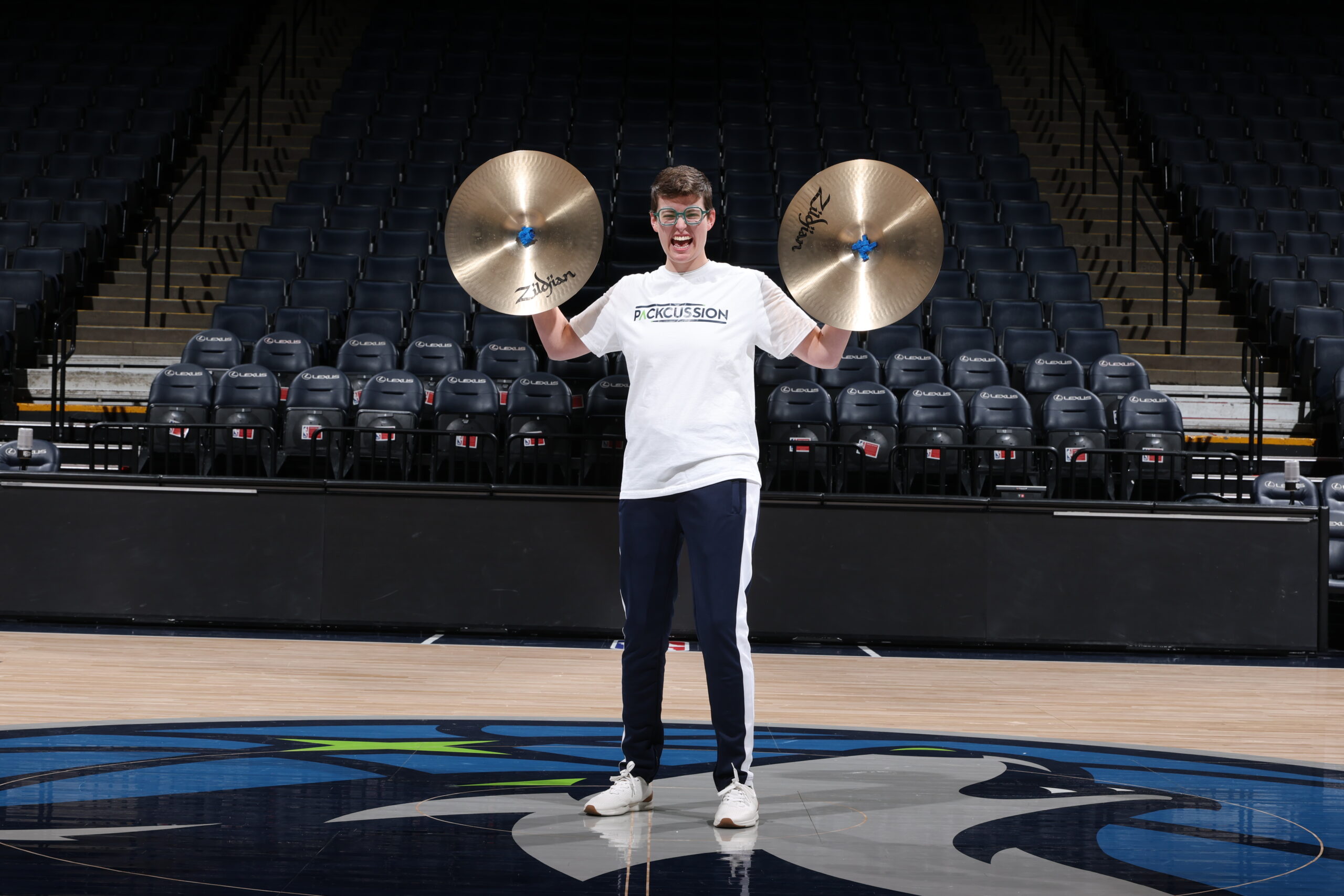 Woman holding cymbals on a basketball court